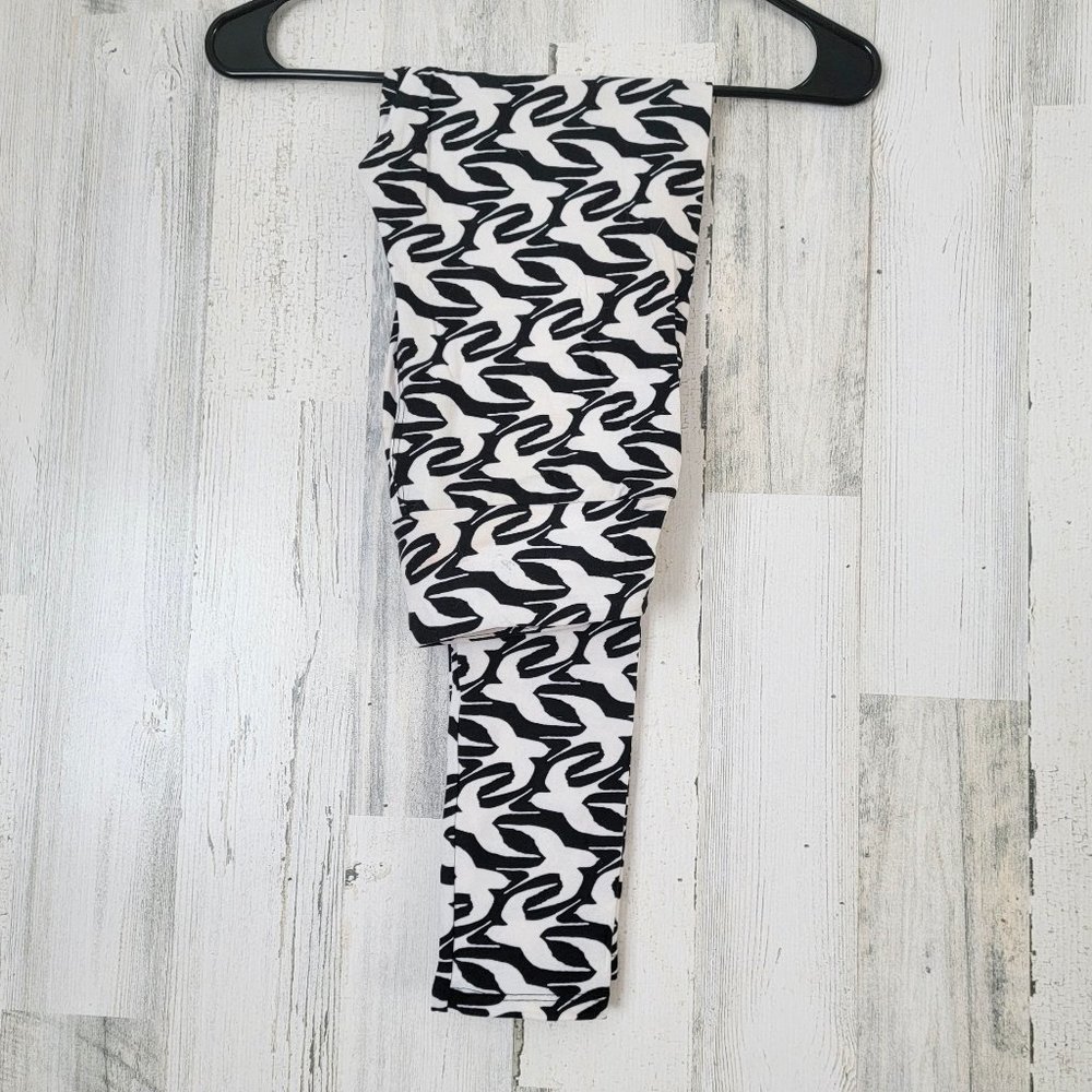 Leggings with a black background and birds in white